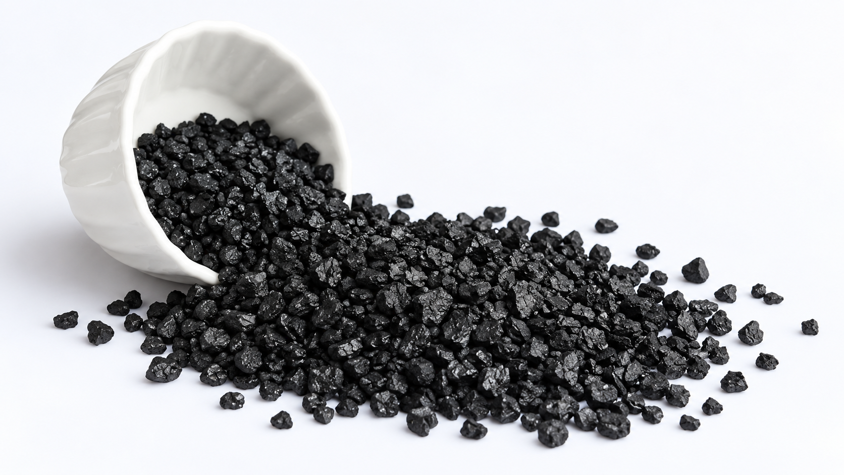 Coal-based activated carbon spilling from a white bowl